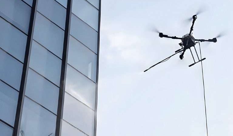 Un drone de nettoyage haute pression intervient sur un bâtiment bancaire